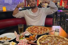 Chris Hemsworth fa i 'muscoli' a tavola, tra pizze e fritti.