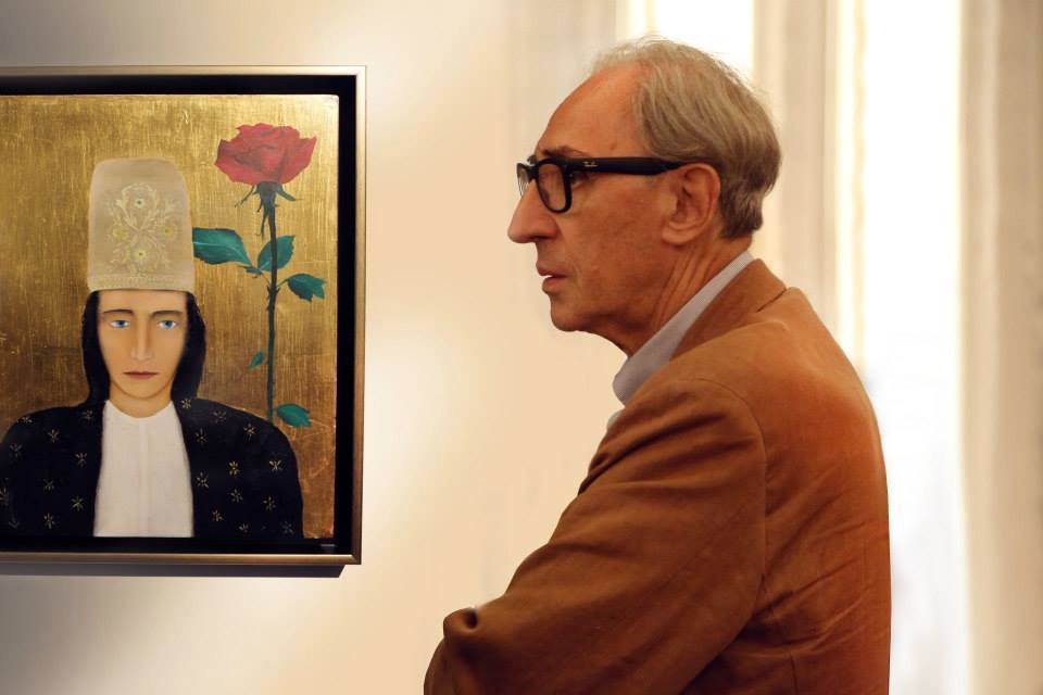 Franco Battiato in posa con un suo dipinto