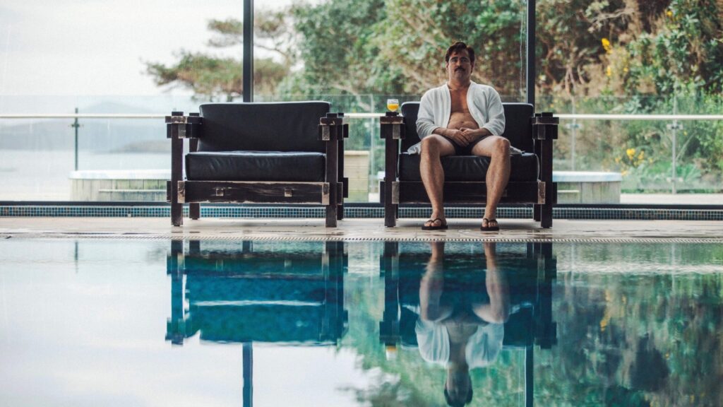 Colin Farrell seduto al bordo della piscina in una scena di The Lobster