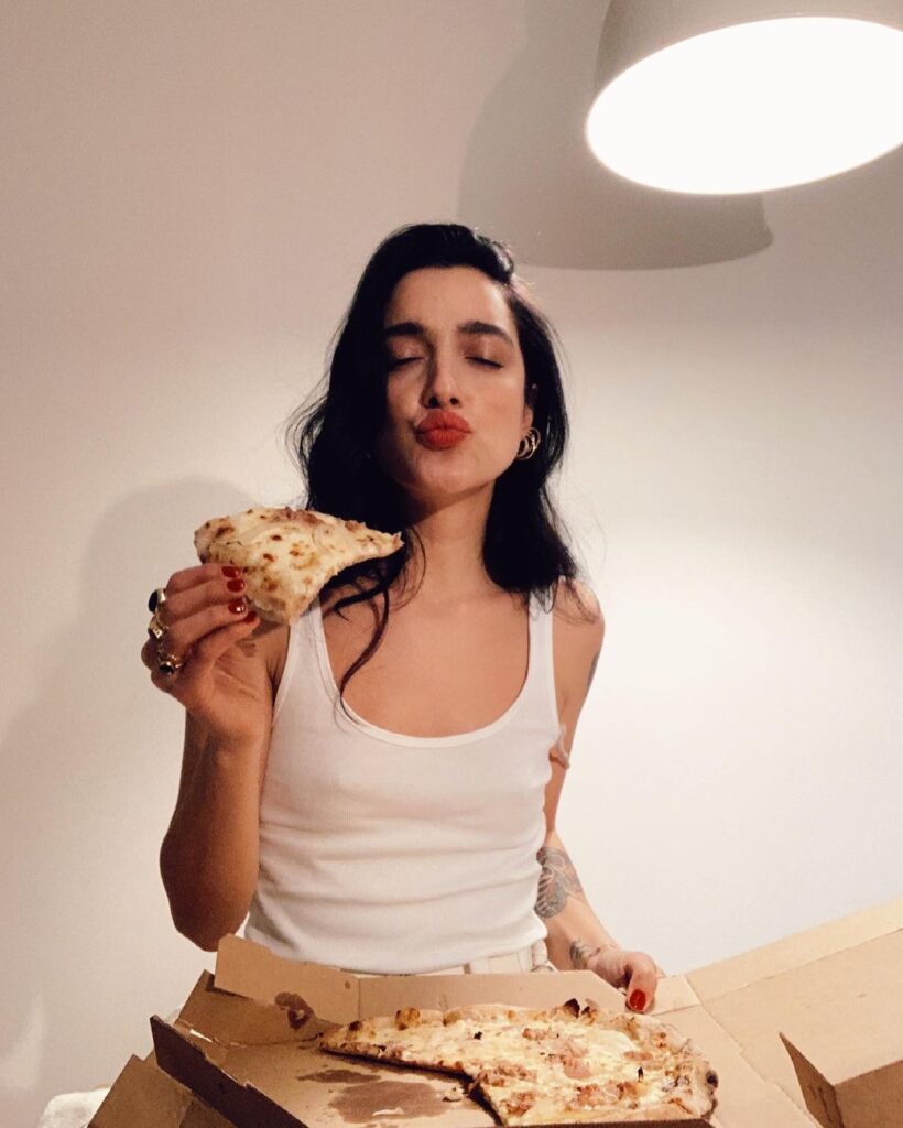 levante sexy senza reggiseno mentre mangia la pizza