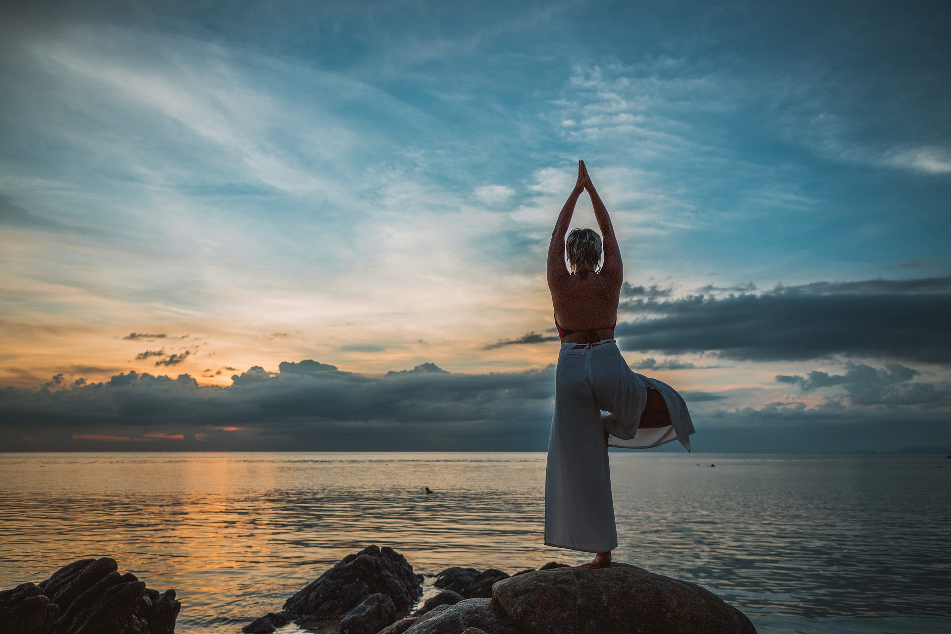 donna fa yoga in riva al mare