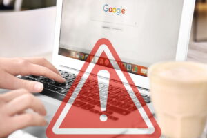 mani che digitano su tastiera, con segnale pericolo