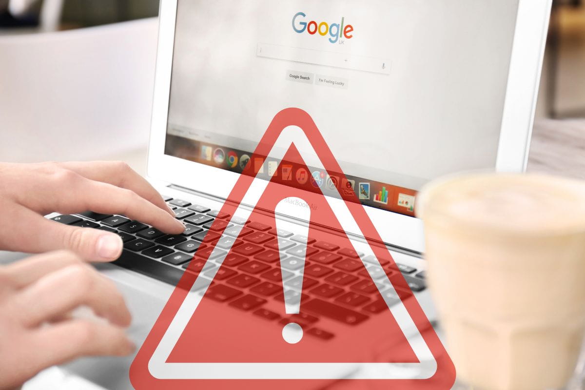 mani che digitano su tastiera, con segnale pericolo