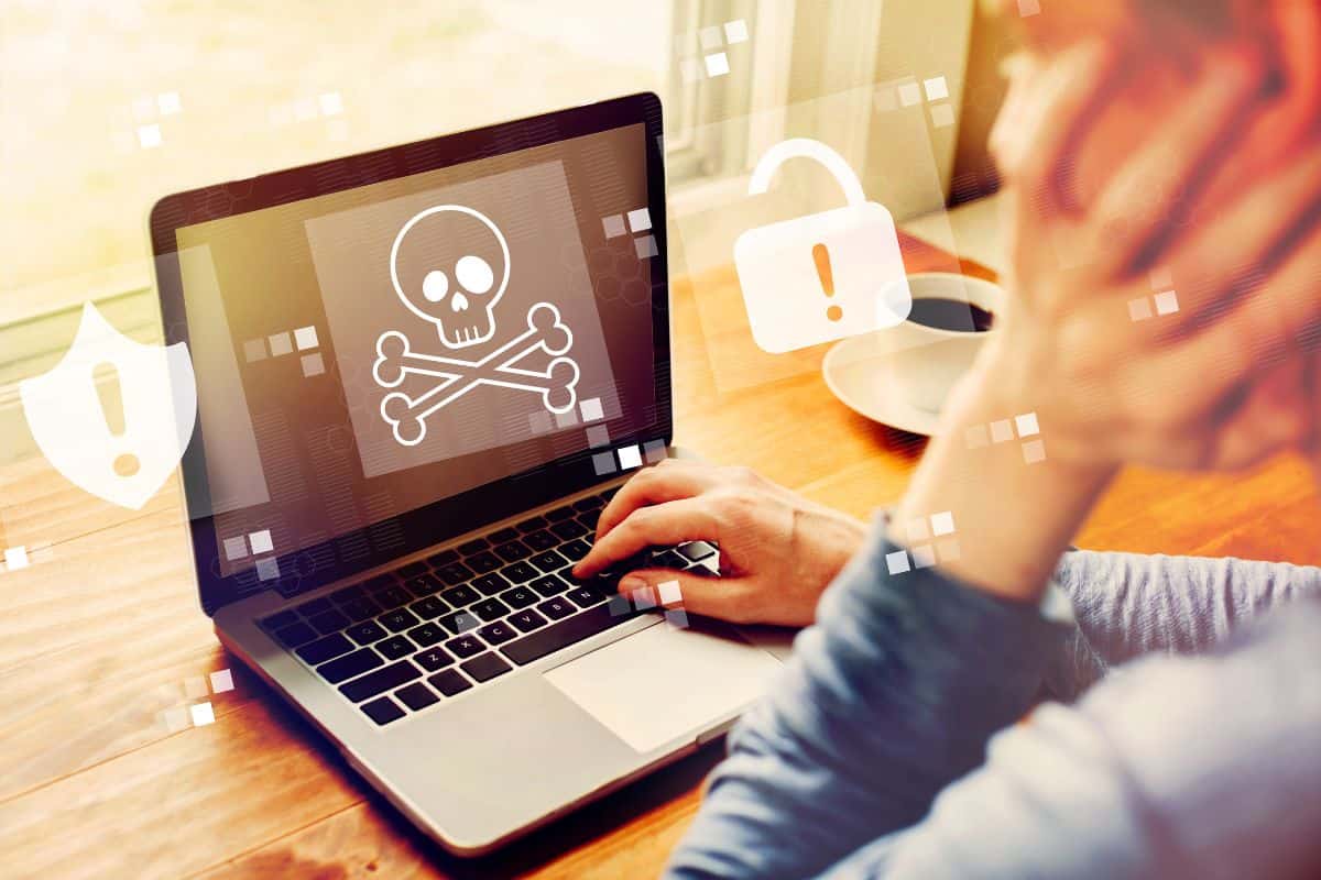 persona che digita su pc e segnale pericolo