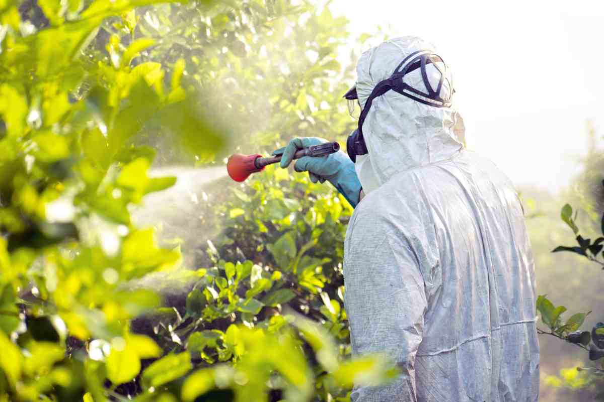 agricoltore spruzza pesticidi