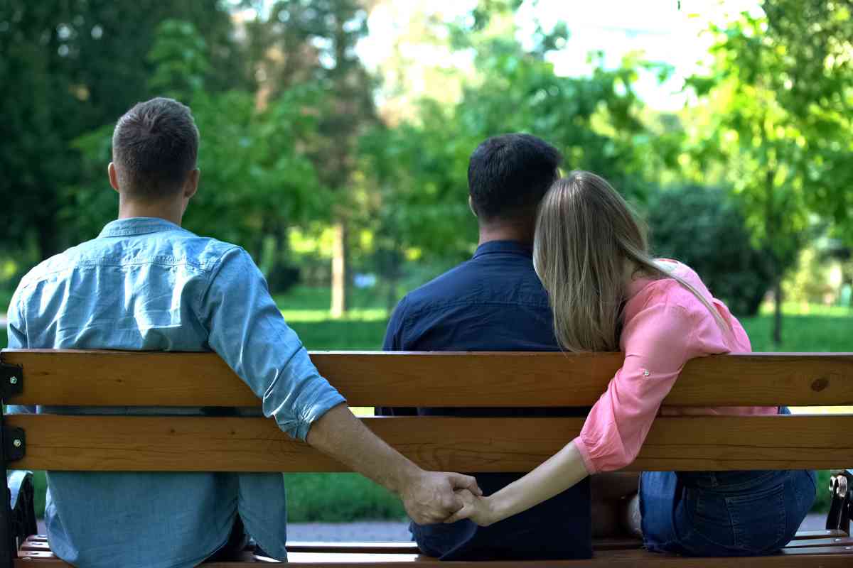 uomo tiene le mani di una ragazza mentre lei è col fidanzato