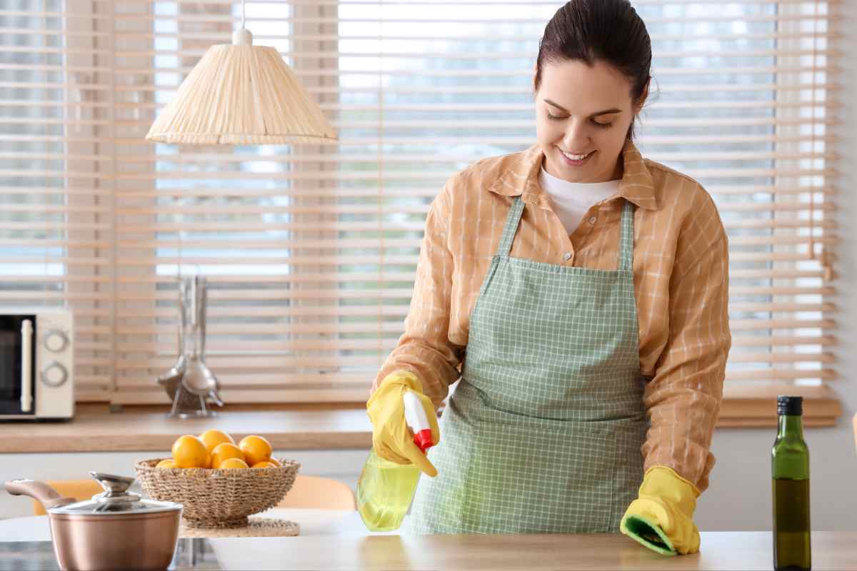 ragazza pulisce piano di lavoro